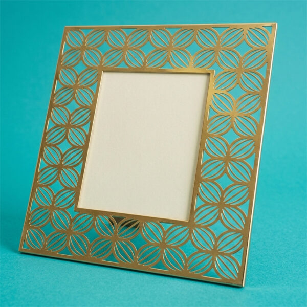 Cornice in metallo traforato color oro con pattern geometrico